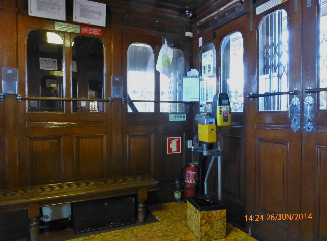 Interior do elevador onde se vê a máquina de compostagem dos bilhetes.