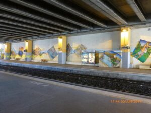 Plataforma da estação ferroviária. O teto foi aproveitado para um amplo estacionamento de veículos; porém, sem cobertura.