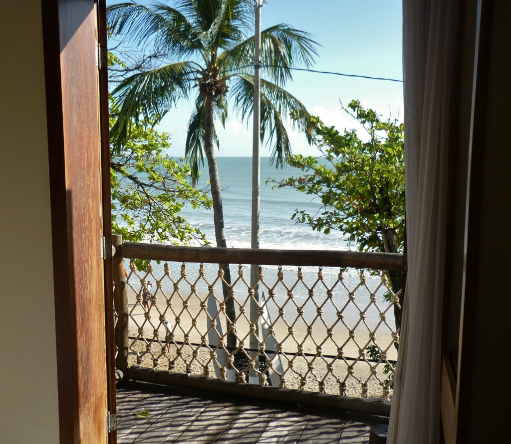 Na foto acima, a praia vista da cama de um dos quartos da parte da frente da pousada. Nada mal acordar e ver uma paisagem linda assim.