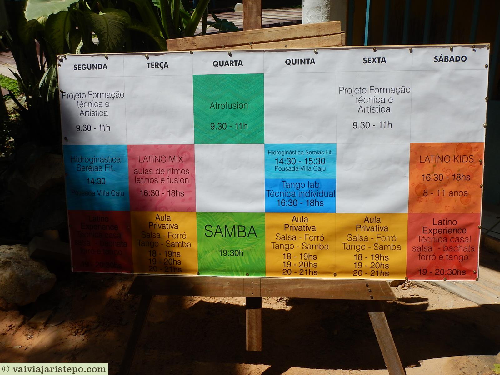 Mais adiante a escola de dança anuncia ritmos e horários de aula. Está colada à agência dos Correios.