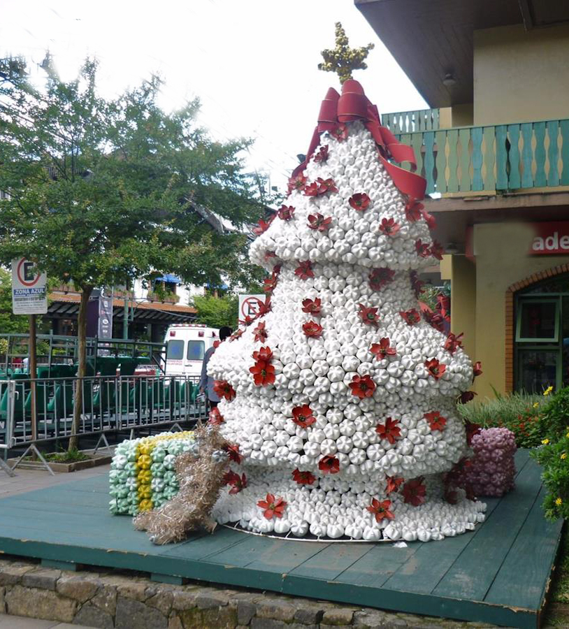 Observem esta árvore de Natal, totalmente confeccionada garrafas pet, incluindo as flores e a estrela do topo.