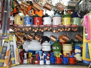 O colorido das mercadorias chega a confundir o consumidor. O ideal é visitá-lo com muita calma e em um só dia vasculhar todos os box é impossível. Neste box, por exemplo, o visitante encontrará brinquedo, ímã de geladeira, e canecas para compor uma bela e atraente mesa de café.